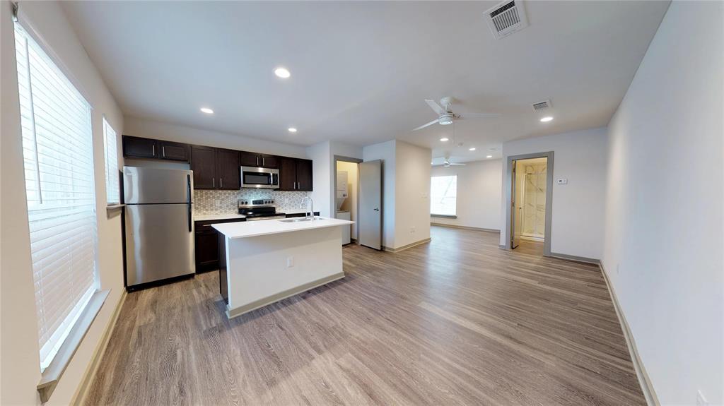 a kitchen with a refrigerator and a stove top oven