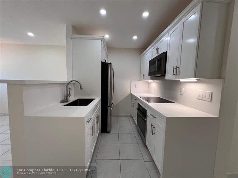 a kitchen with stainless steel appliances granite countertop a sink and a stove