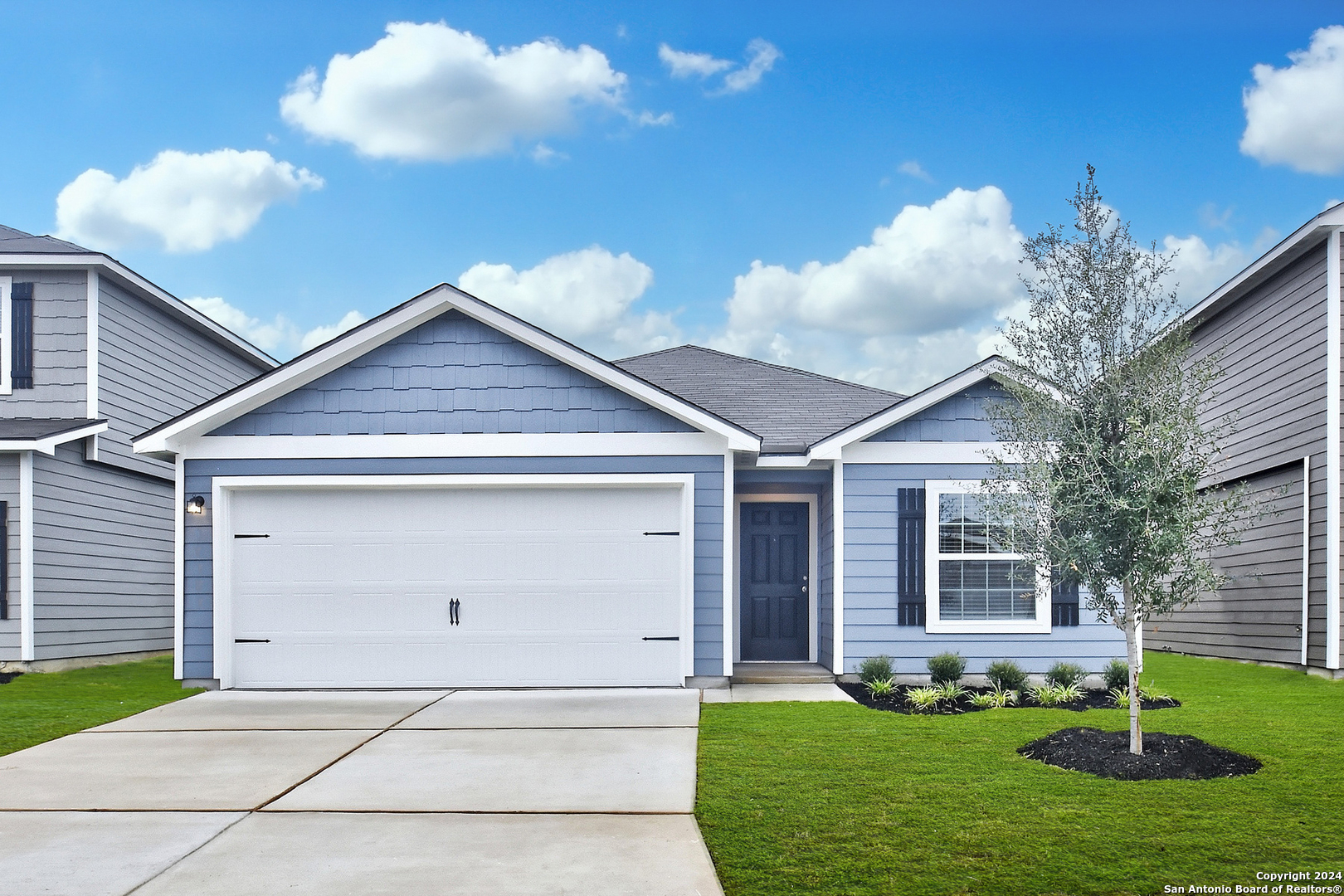 a front view of a house with a yard and garage