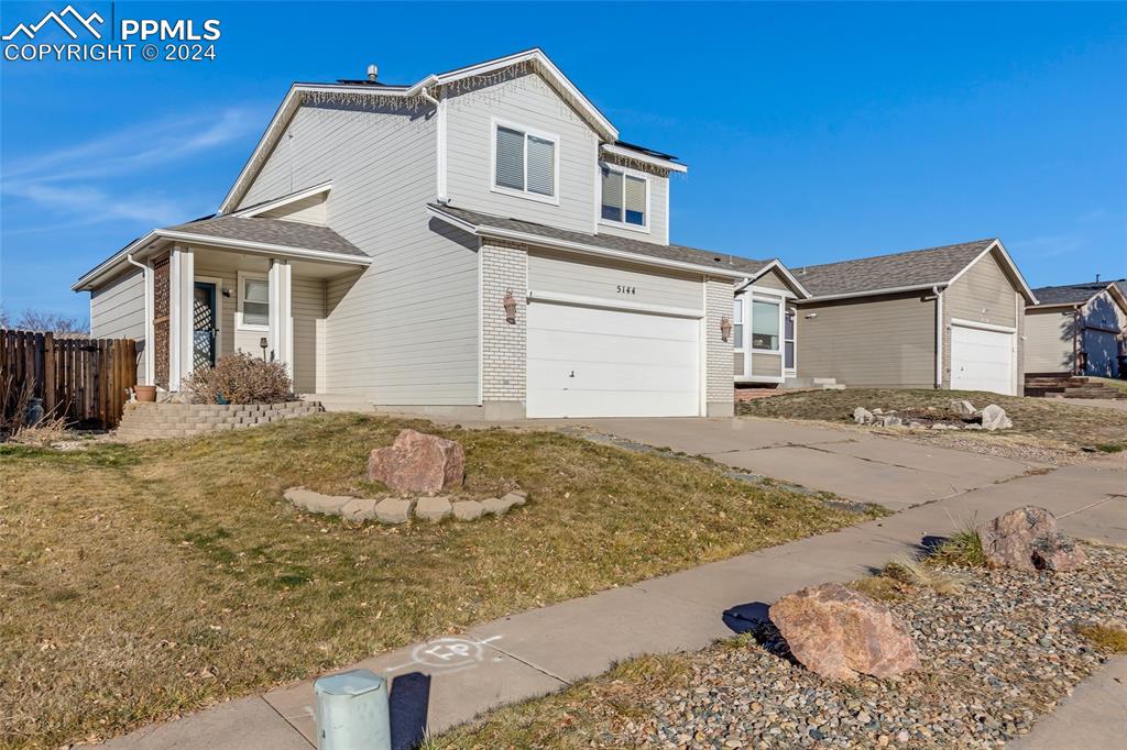 Front of property with a garage and a front lawn