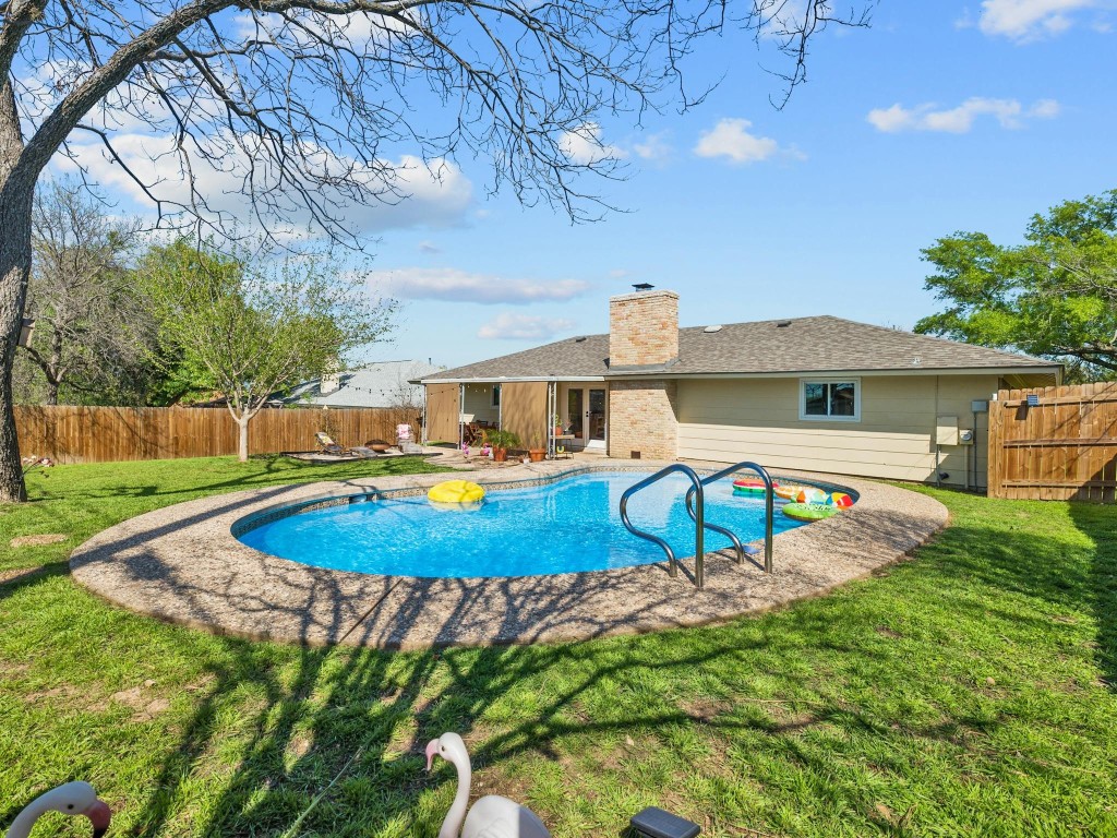 a view of a house with pool and a yard