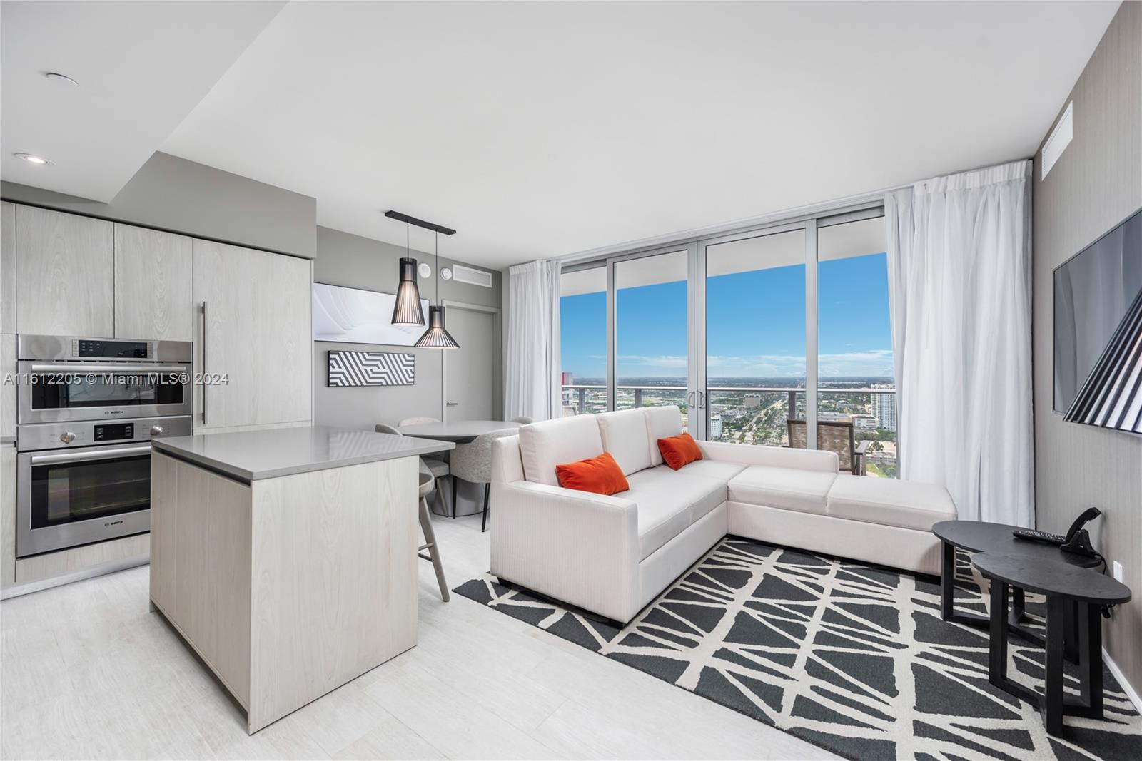 a living room with stainless steel appliances furniture and a window