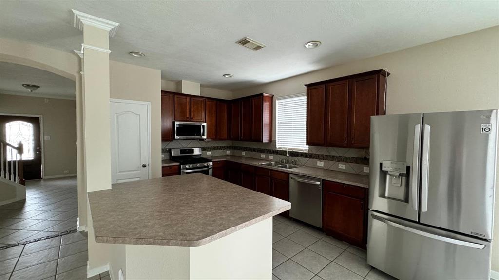 a kitchen with stainless steel appliances granite countertop a refrigerator stove microwave and sink