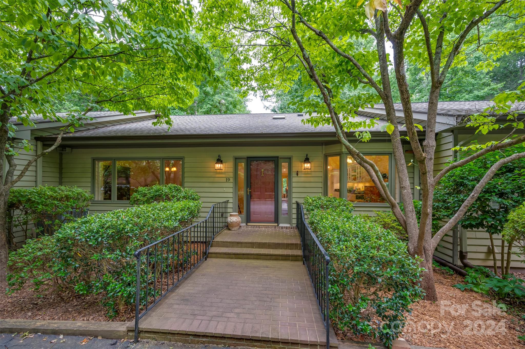 a front view of a house with a garden