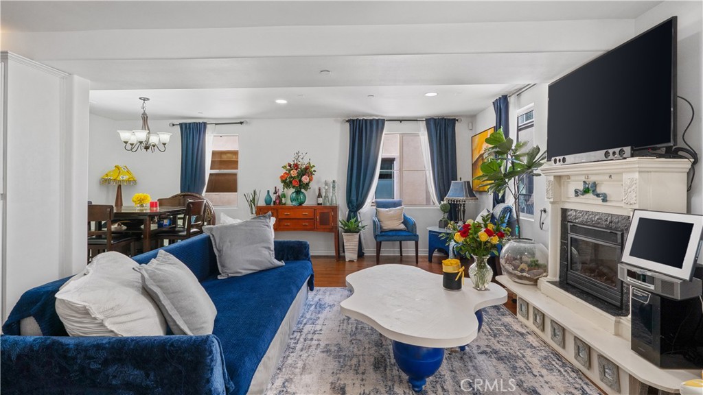 a living room with furniture a flat screen tv and a fireplace