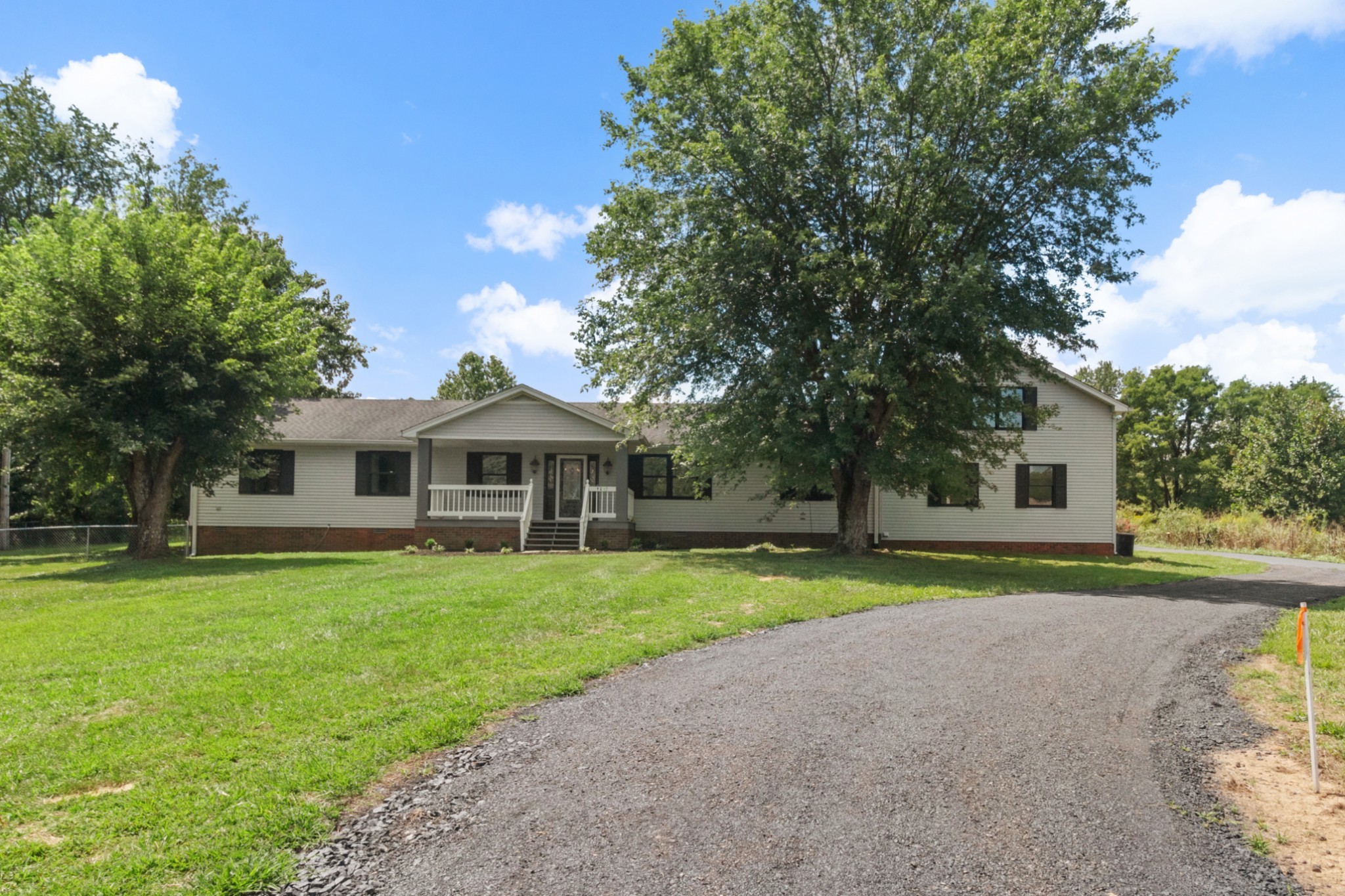 a front view of a house with a yard and trees