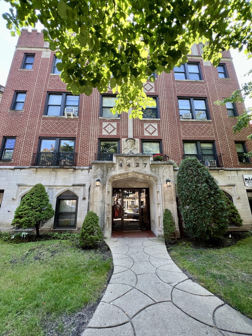 front view of a brick house with a yard