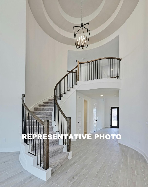 a view of staircase with railing and chandelier