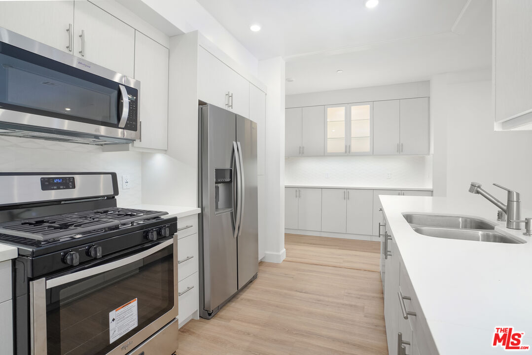 a kitchen with stainless steel appliances granite countertop a stove microwave and refrigerator