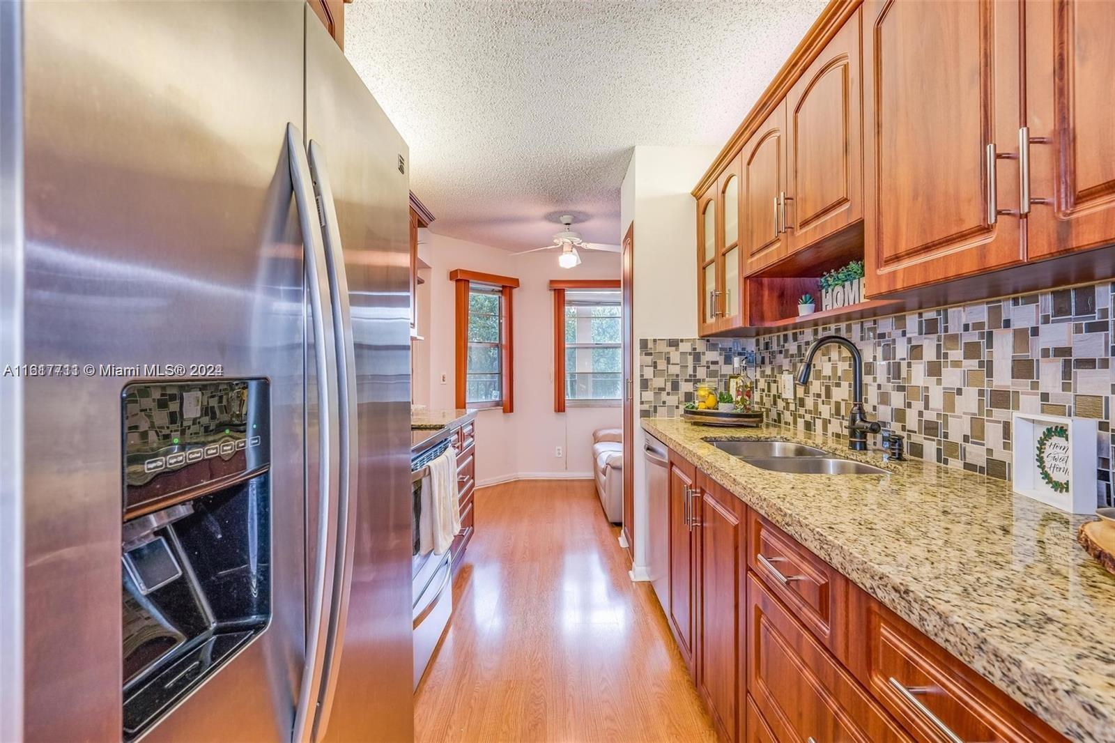 a kitchen with kitchen island granite countertop a stove and a wooden floors