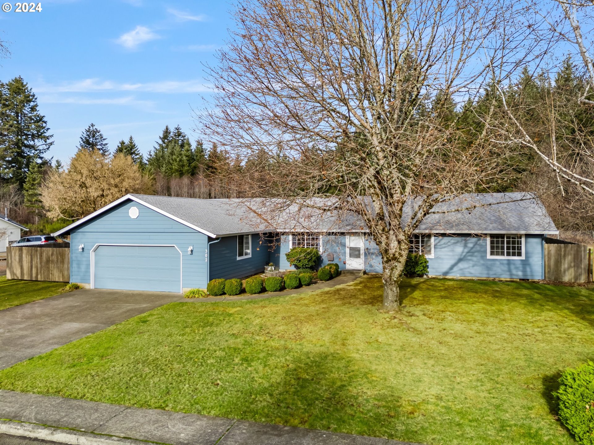 a front view of house with yard and trees around