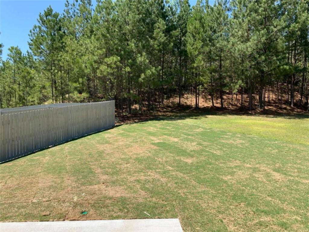 a view of a swimming pool with an outdoor seating and a forest