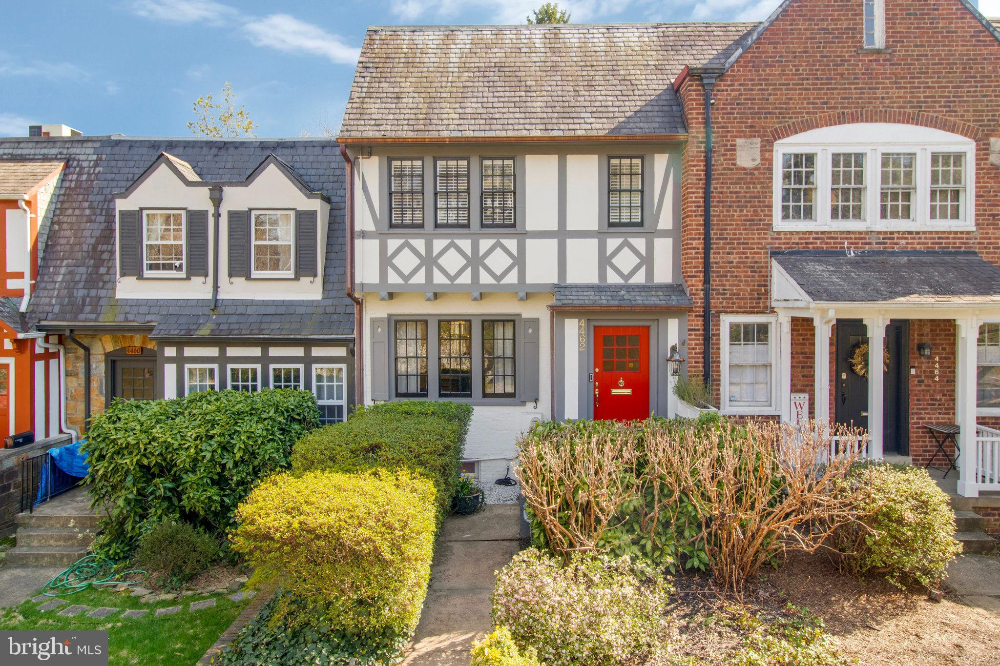 front view of a brick house with a lots of windows and a yard