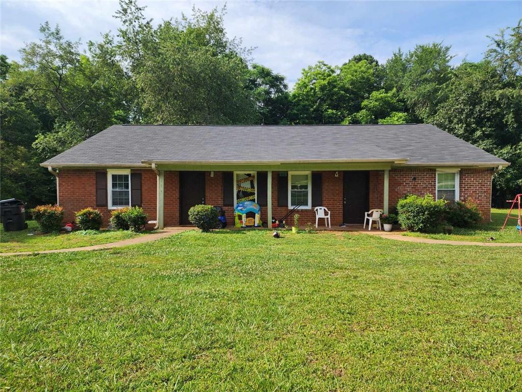 a front view of a house with a yard deck and green space