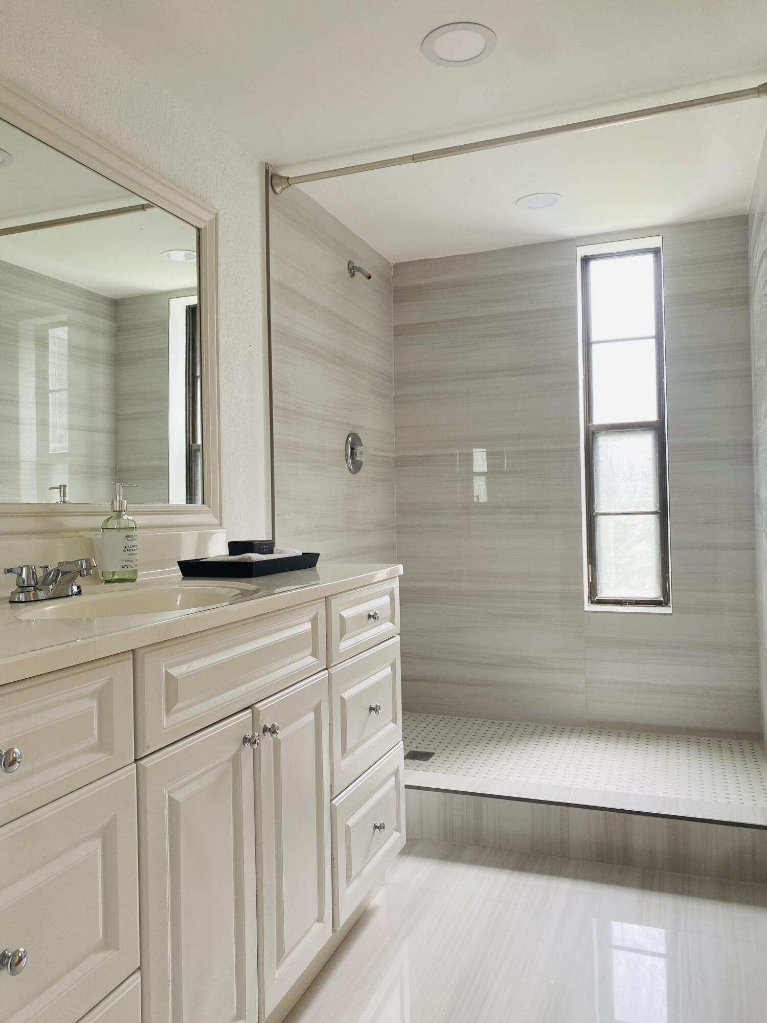 a bathroom with a double vanity sink a mirror and a bathtub