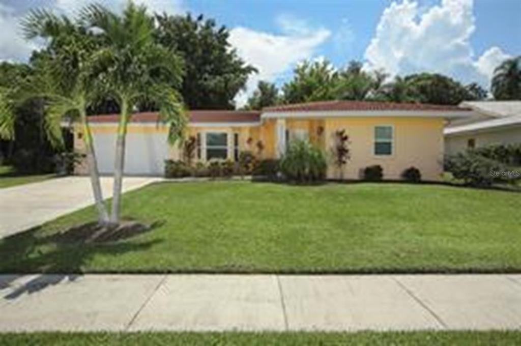 a view of a house with a yard and sitting area