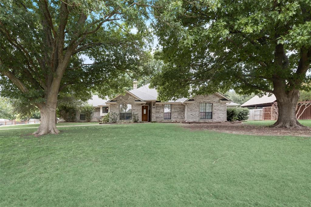 a front view of a house with a yard and trees