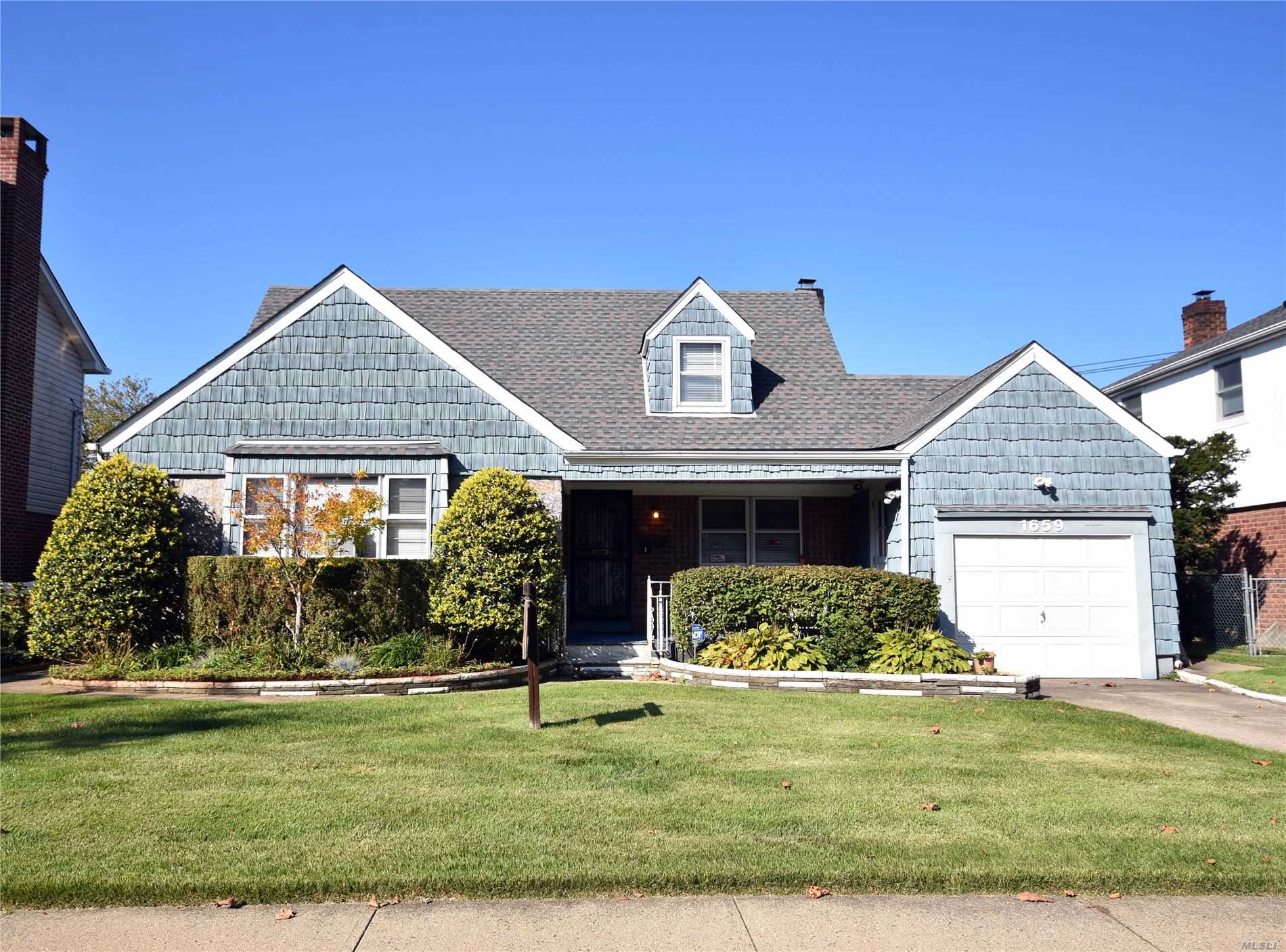 a front view of a house with a garden