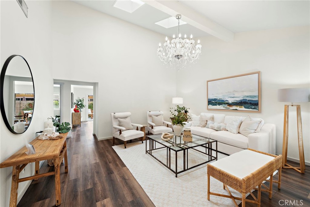 a living room with furniture a chandelier and a mirror