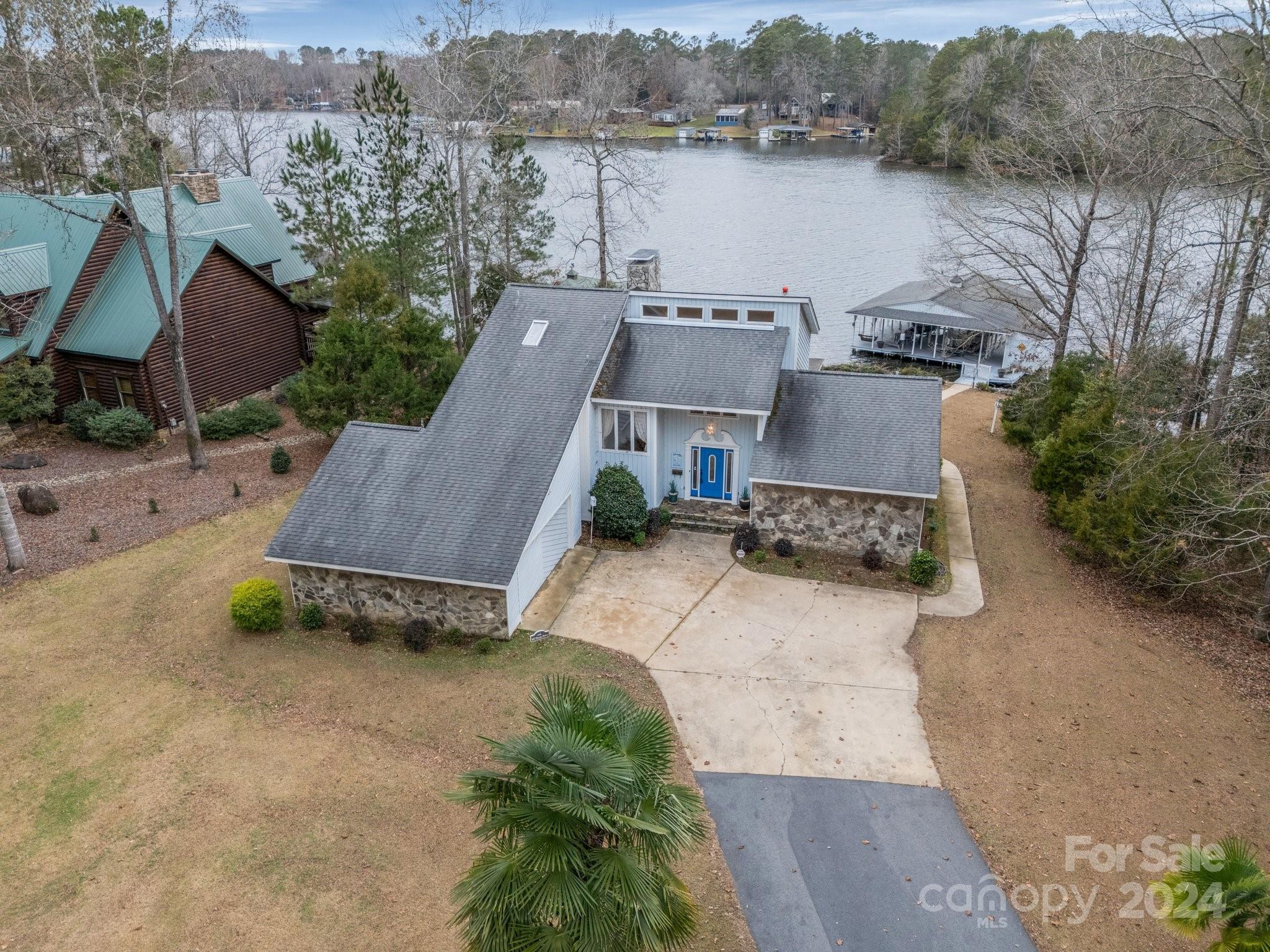 an aerial view of a house with a garden and lake view