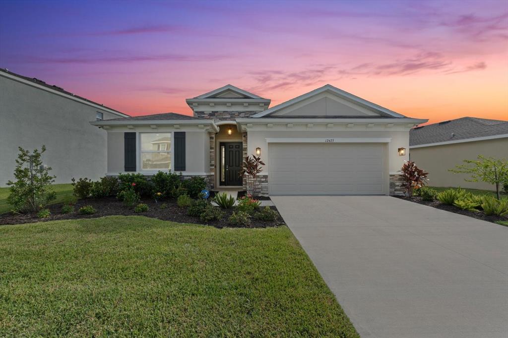 a front view of a house with yard and garage