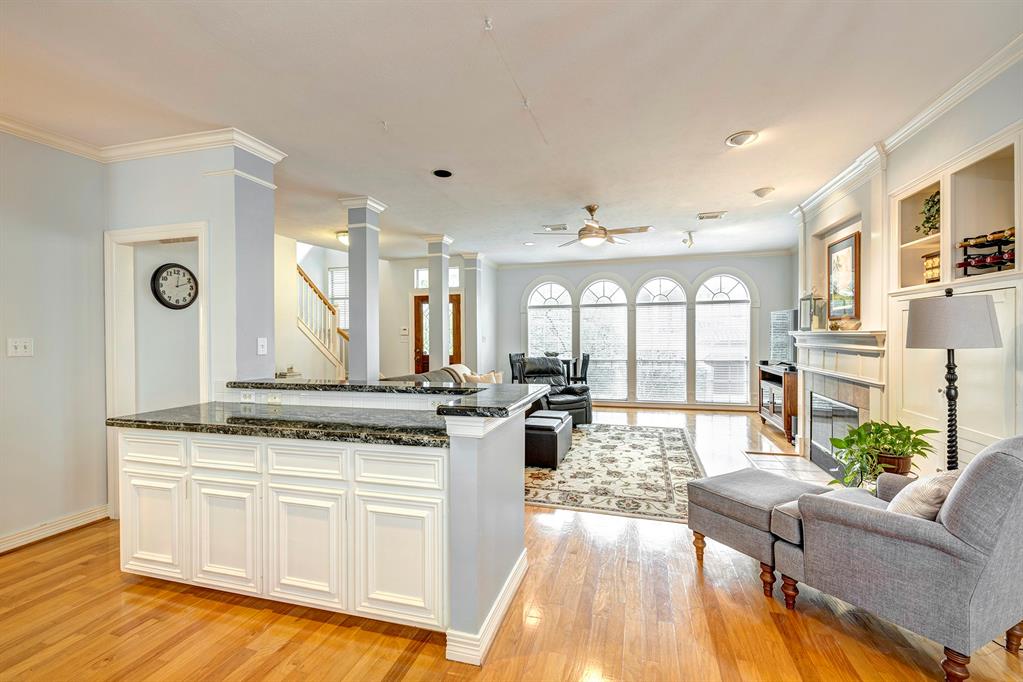 a view of a kitchen with kitchen island granite countertop a stove and a view of living room