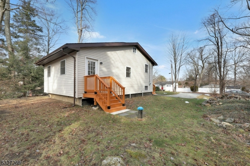 a view of backyard of house with outdoor seating and trees in the background