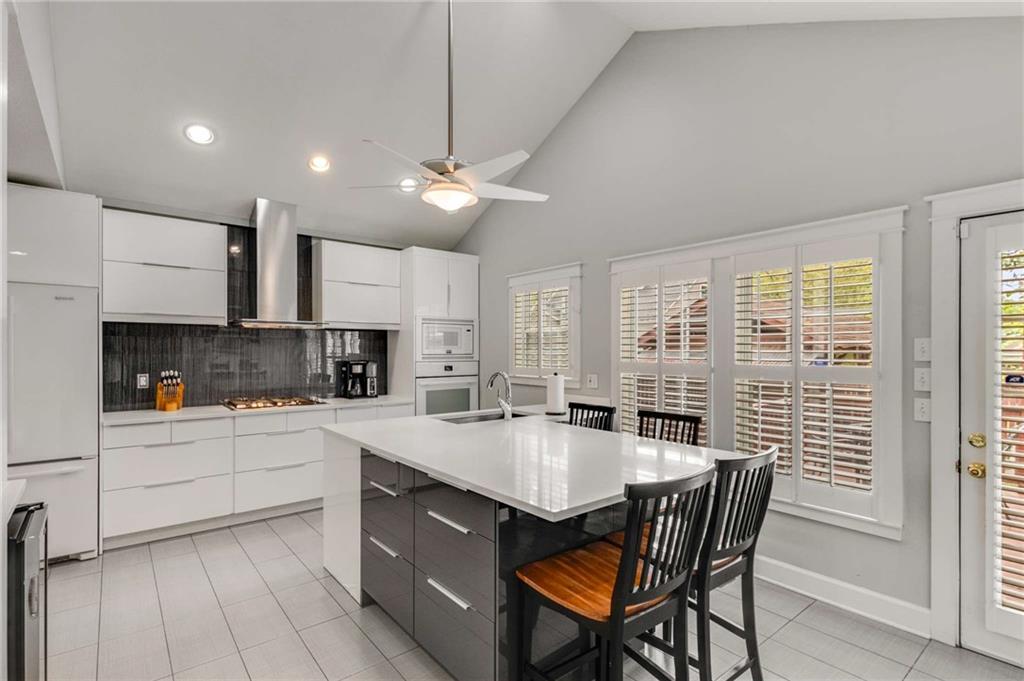 a large kitchen with kitchen island a dining table chairs and a sink