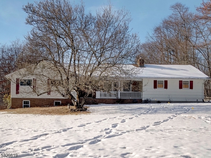 a front view of a house with a yard covered in snow