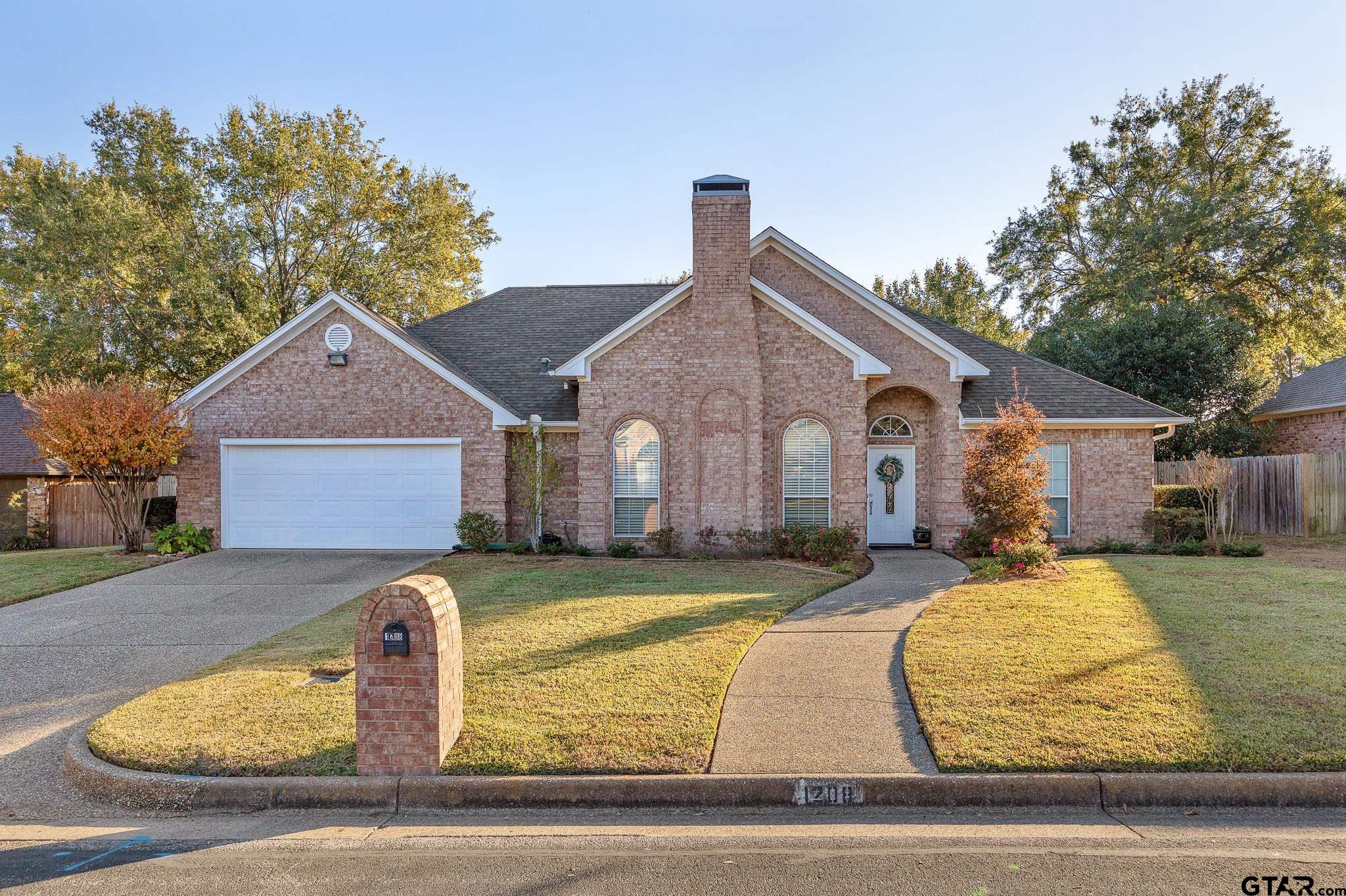 a front view of house with yard and trees