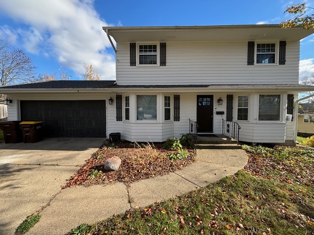 a front view of a house with yard garage and seating space