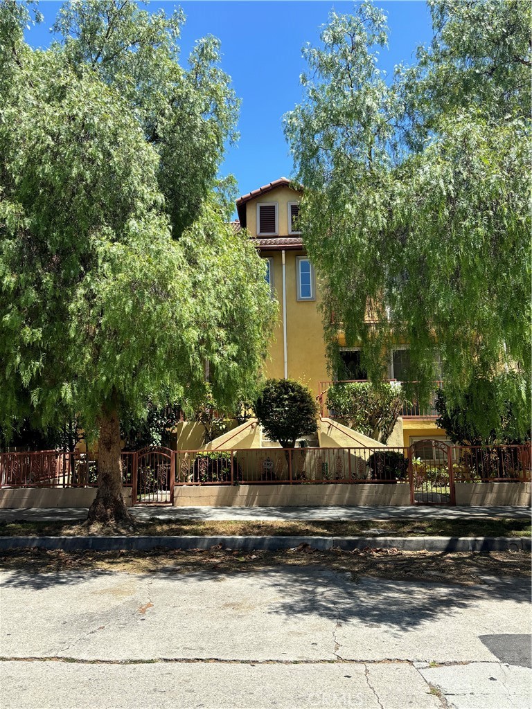 a view of a house with a yard and large tree