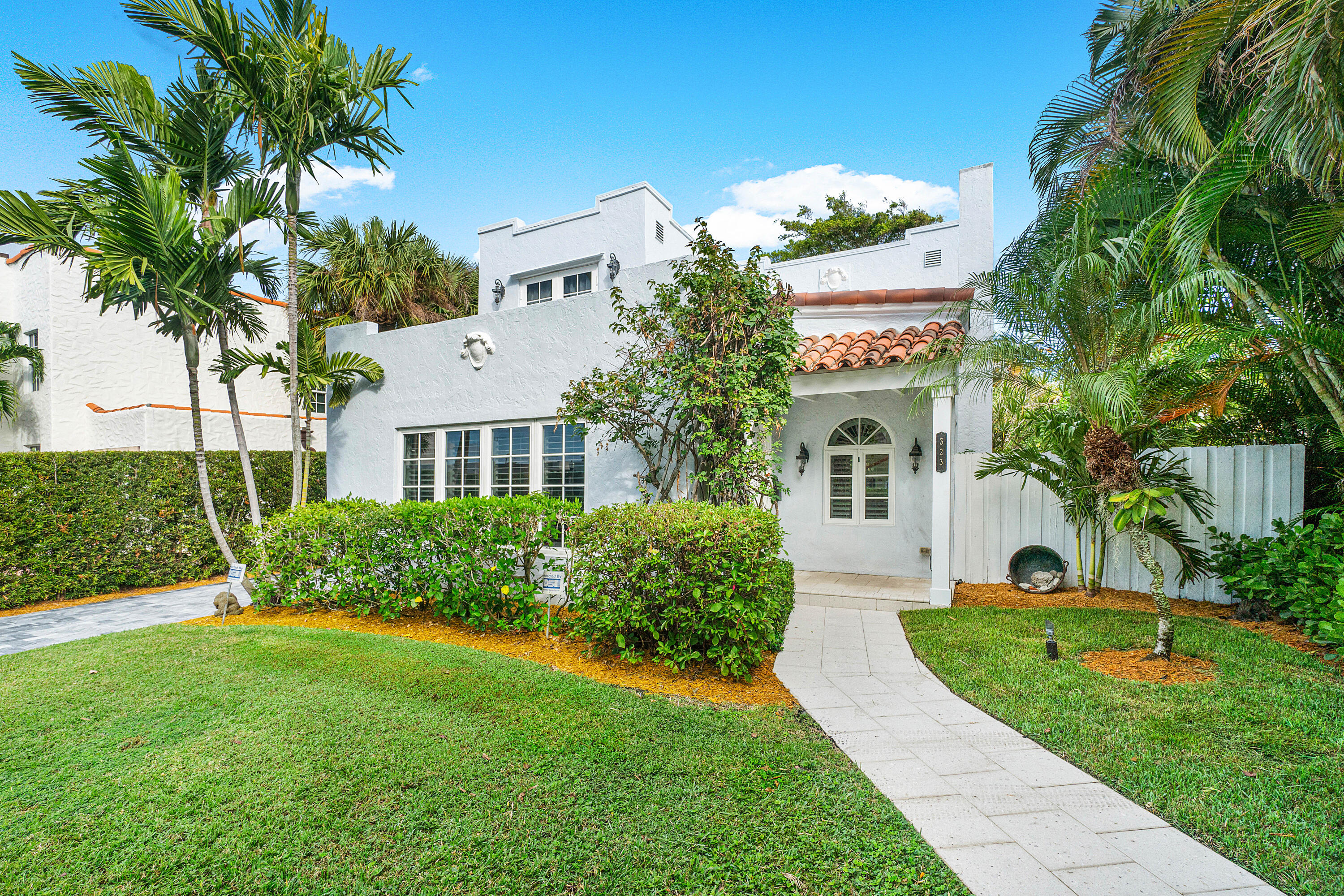 a front view of a house with a garden and plants