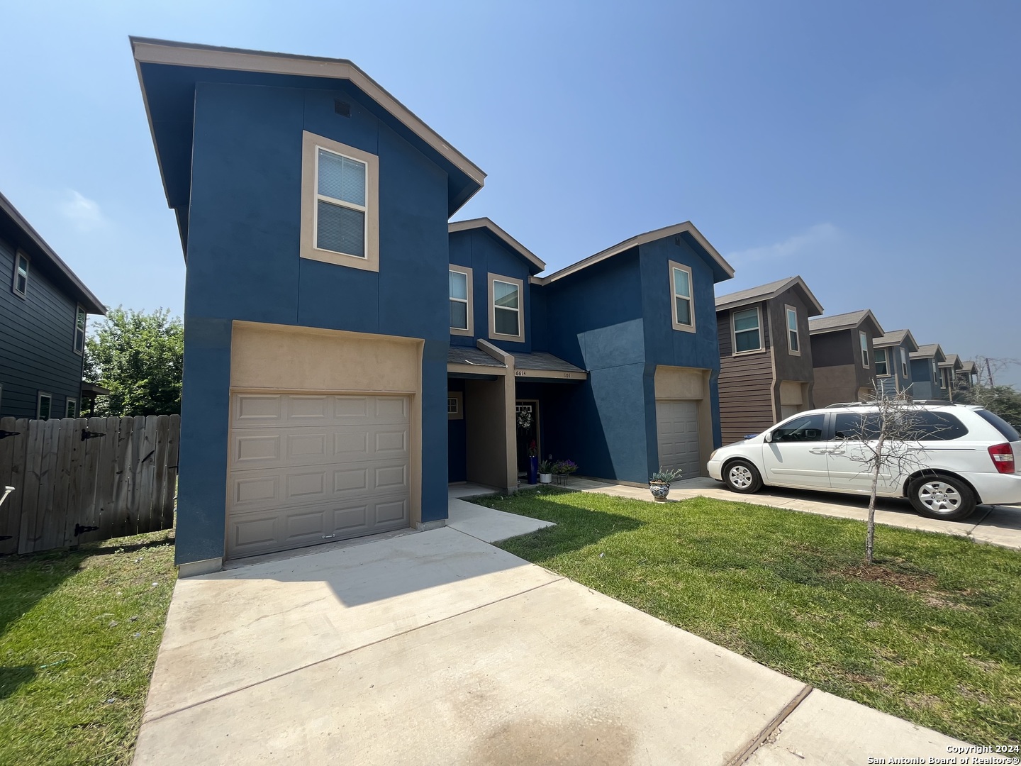 a view of a car parked in front of a house with a yard