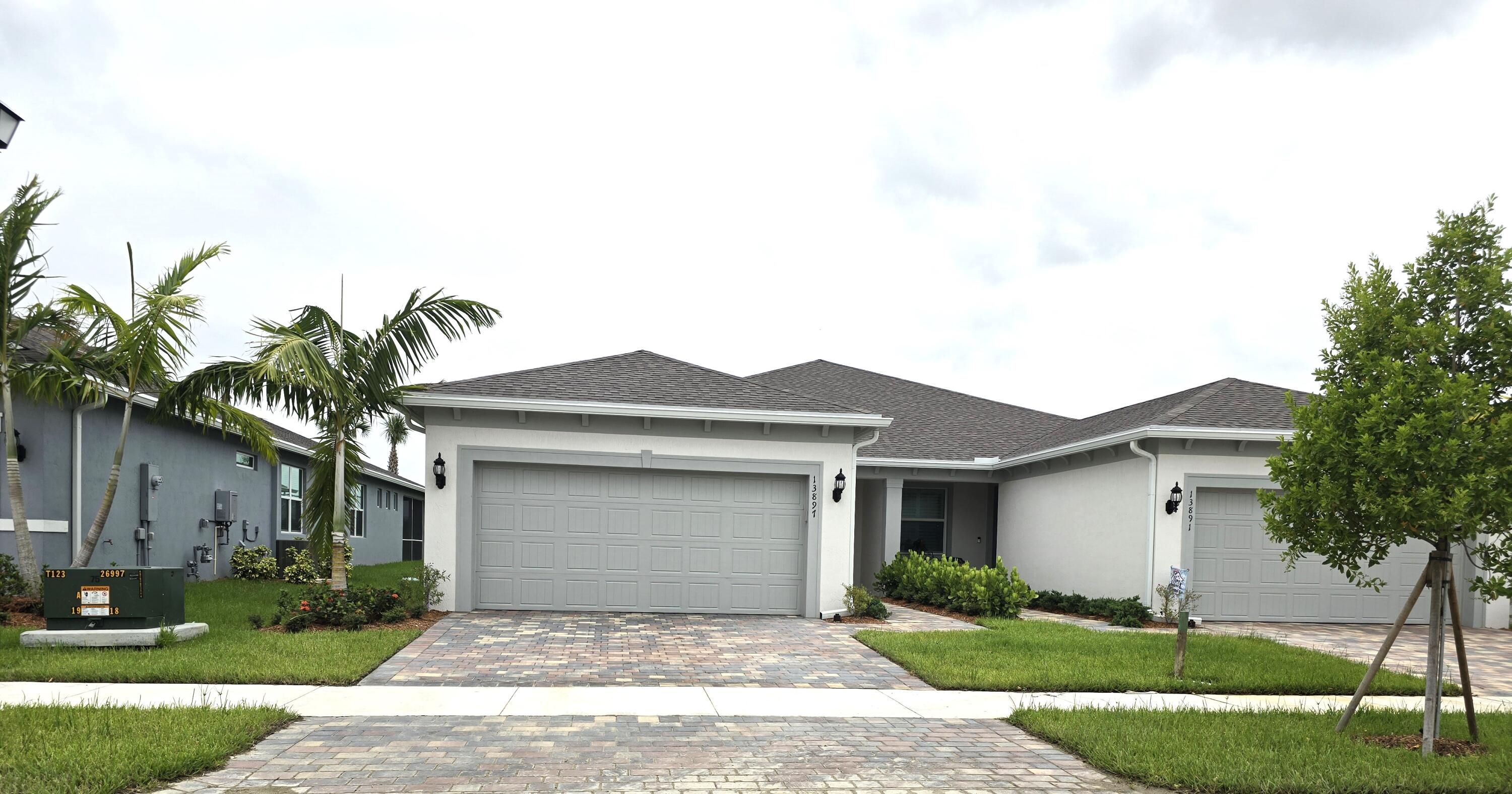 a front view of a house with a garden and yard