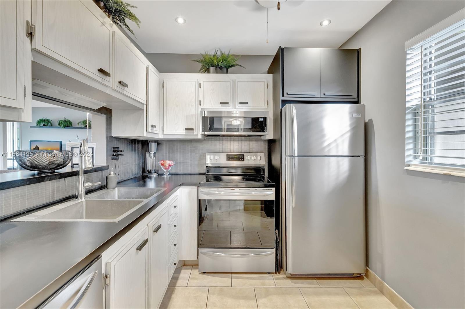 a kitchen with stainless steel appliances a refrigerator sink and cabinets