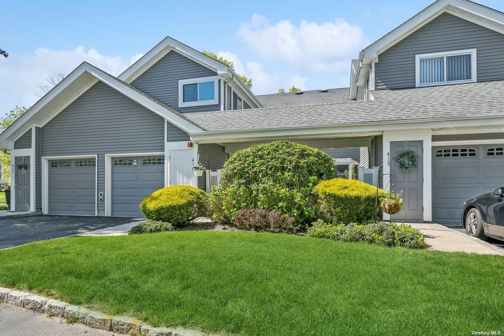 a front view of a house with a garden and plants