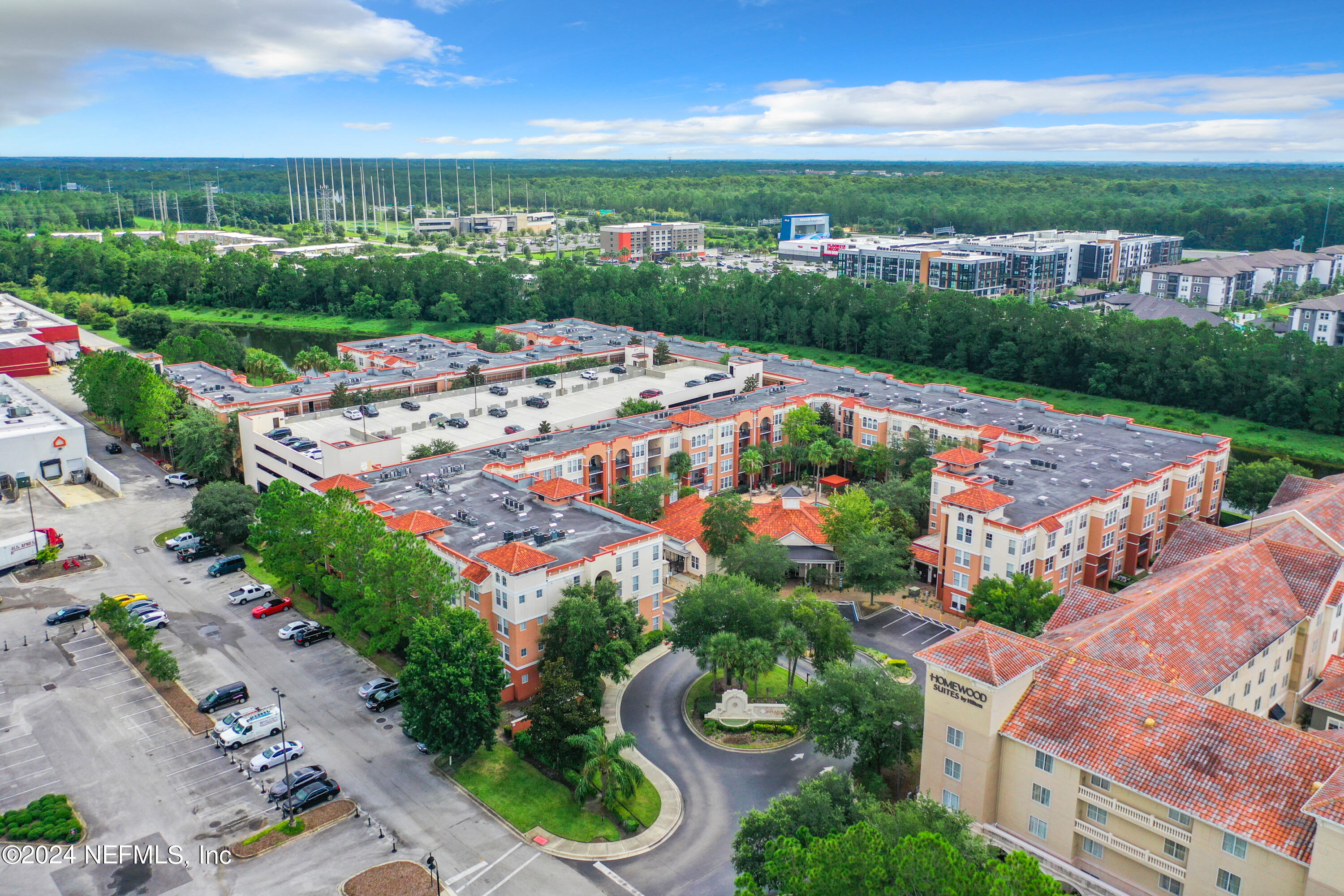 an aerial view of a city with lots of residential buildings ocean and mountain view in back