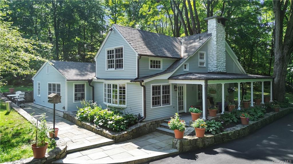 View of side of house stone walks, walls and porch