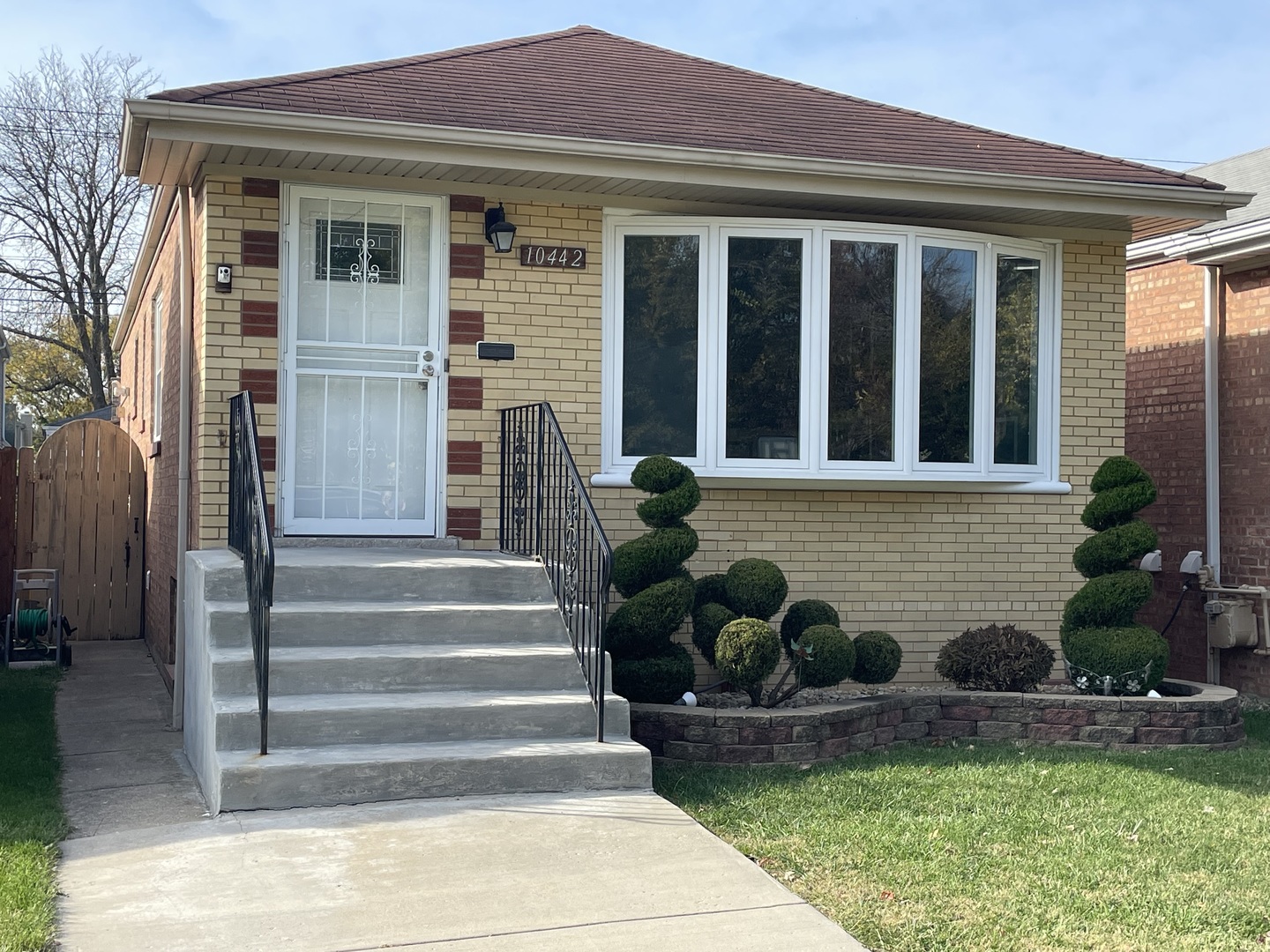 a front view of a house with plants