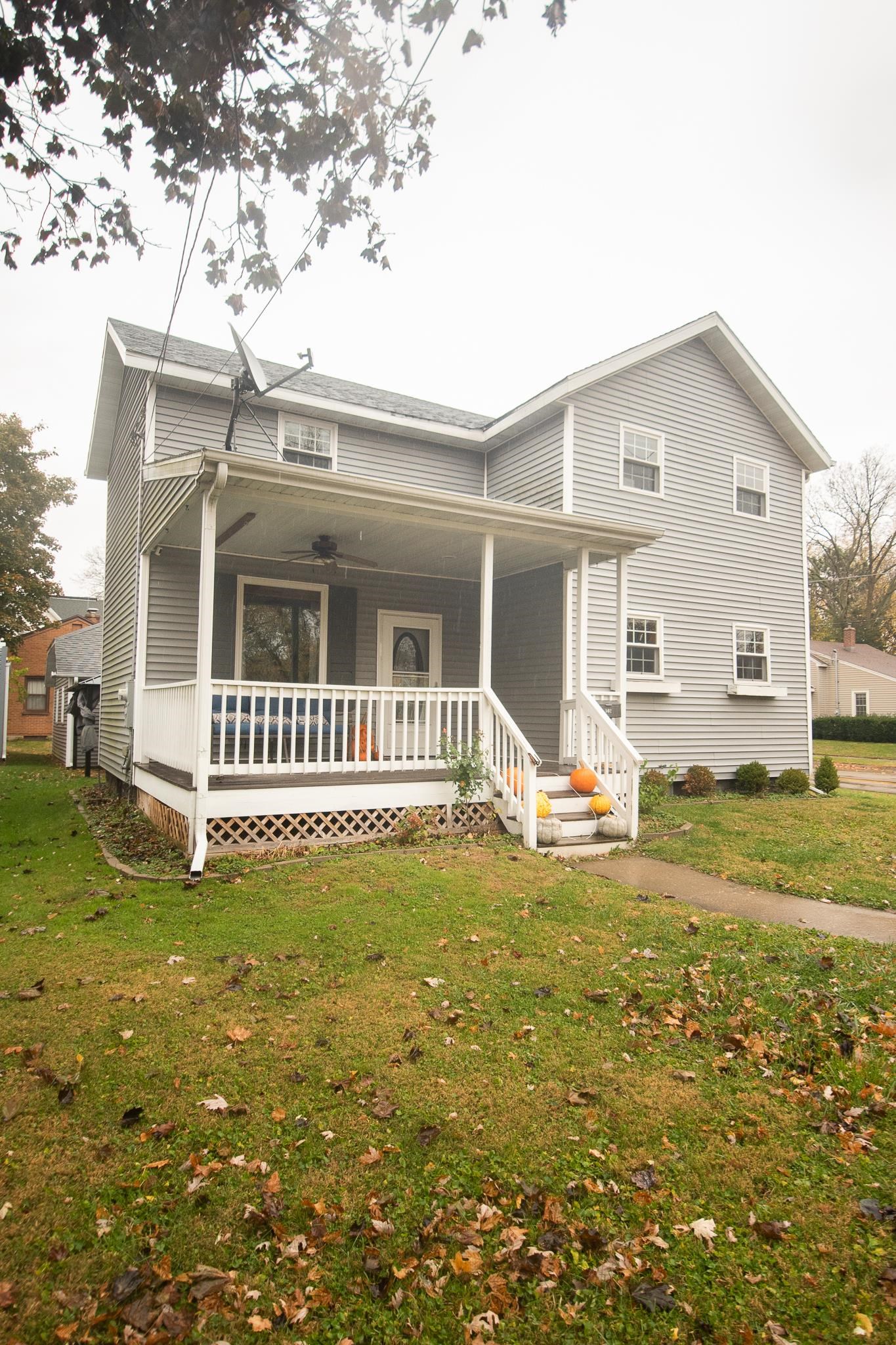 a view of a house with a big yard and large tree