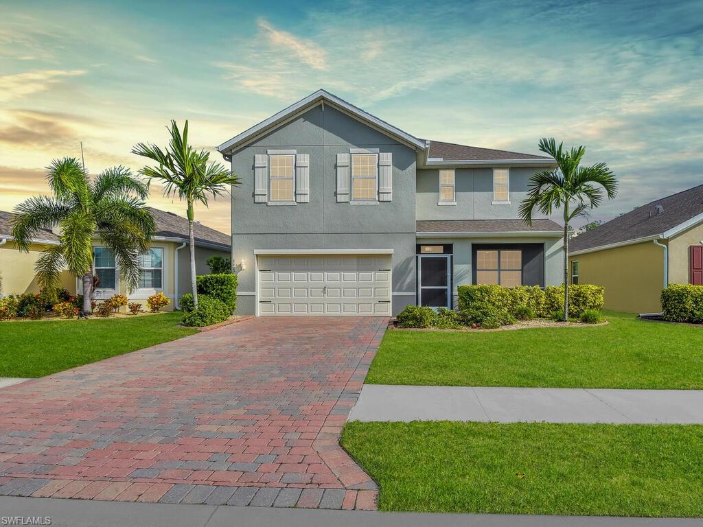 View of front of house with a yard and a garage