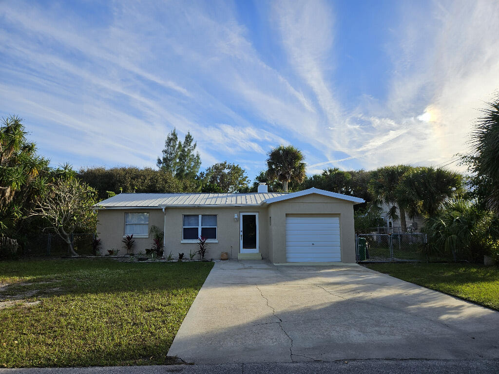 a front view of a house with a garden and yard