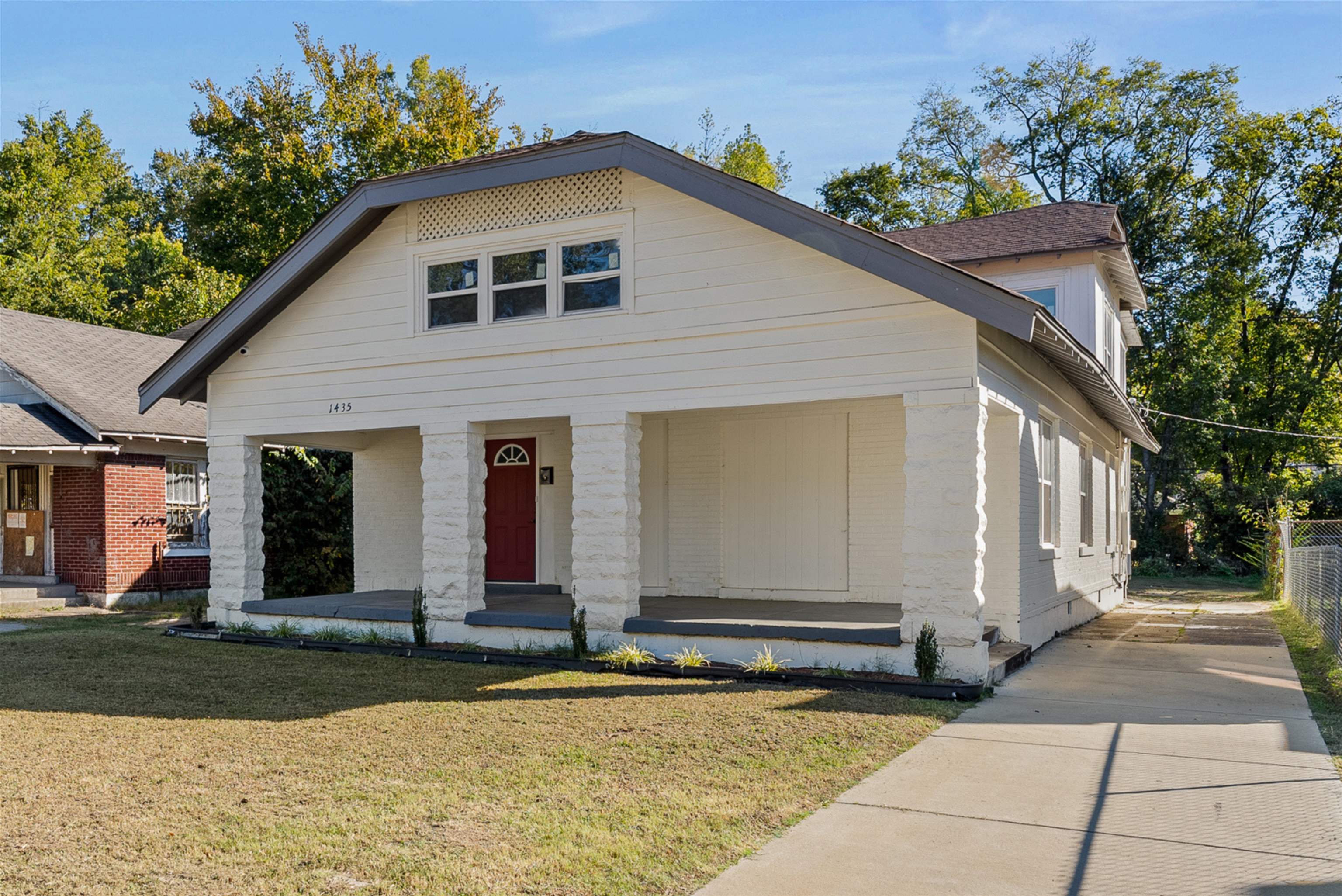 View of front facade with covered porch and a front lawn