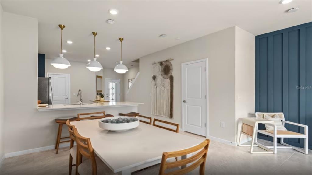 a view of a a dining room and kitchen with a table chairs