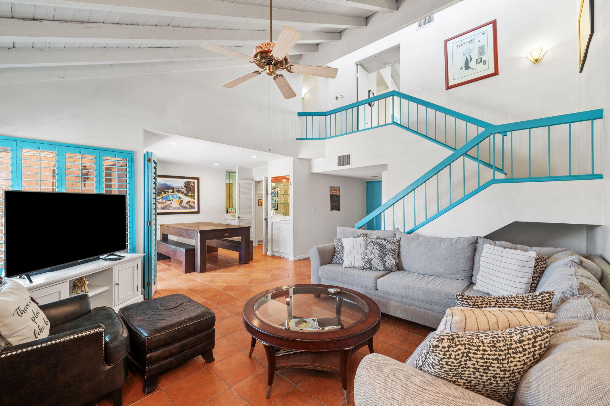 a living room with furniture a ceiling fan and a flat screen tv