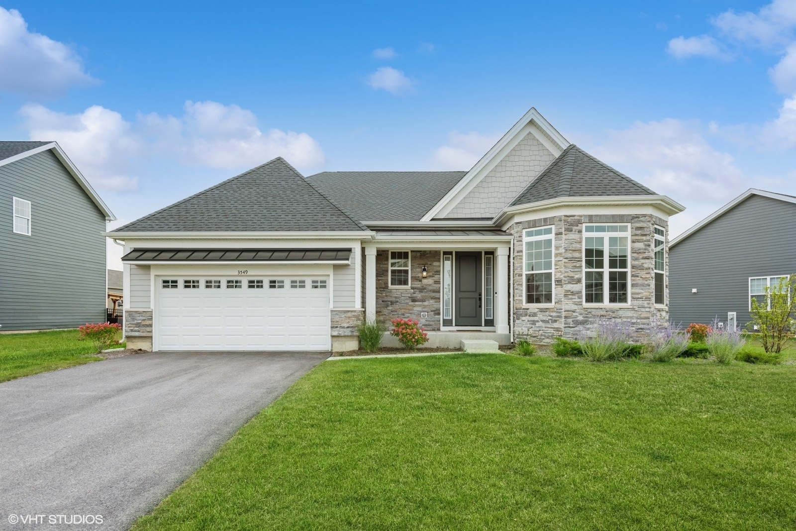 a front view of a house with a garden and yard