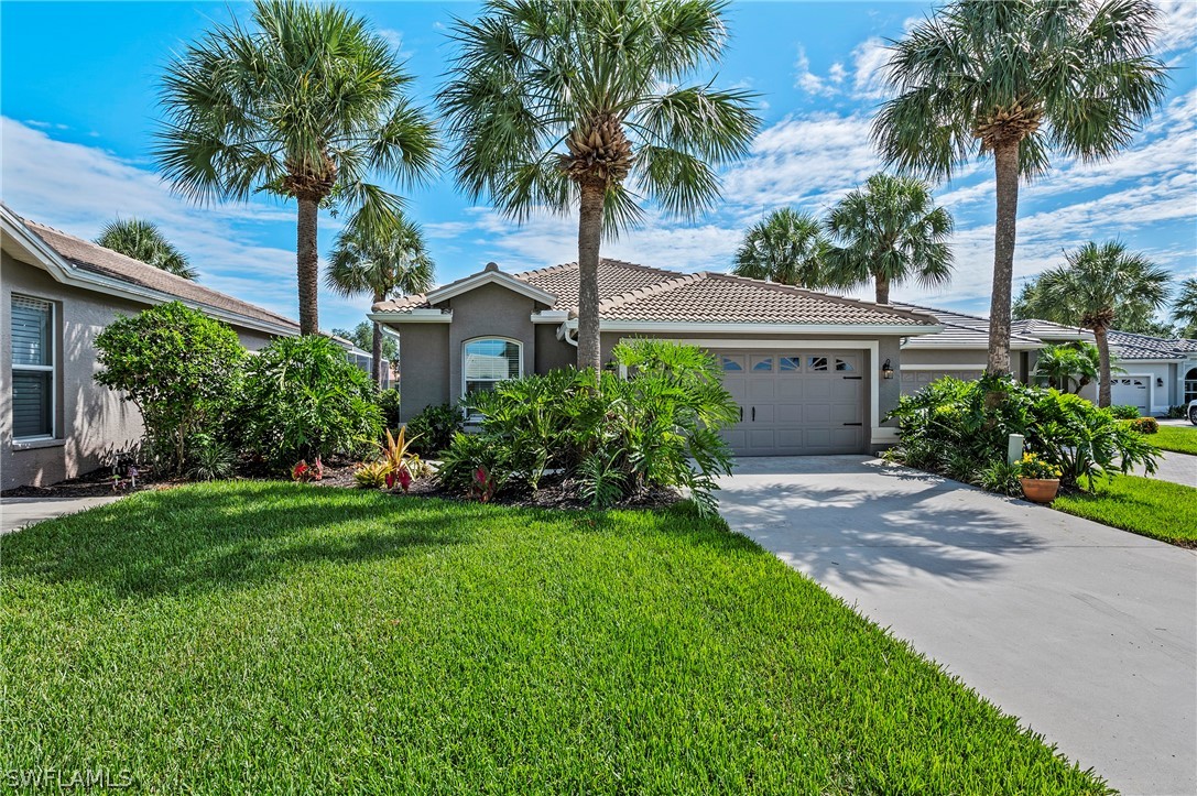 a front view of a house with a garden and palm trees