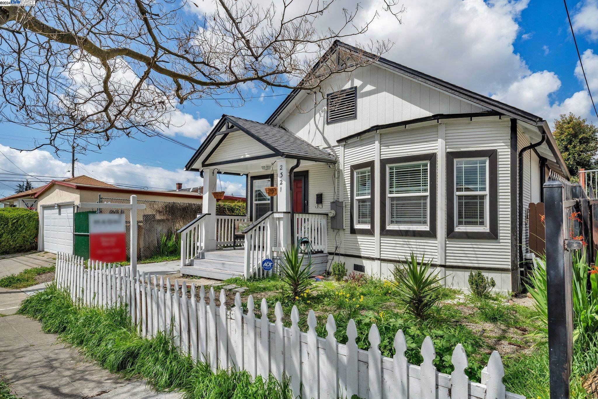 a view of a house with wooden fence next to a yard