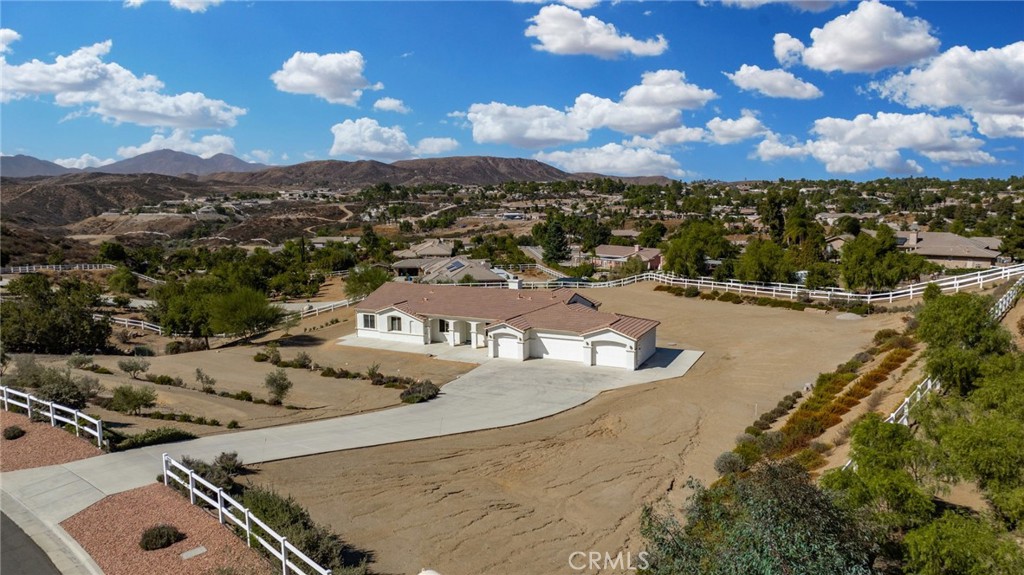 an aerial view of a house with swimming pool and mountains